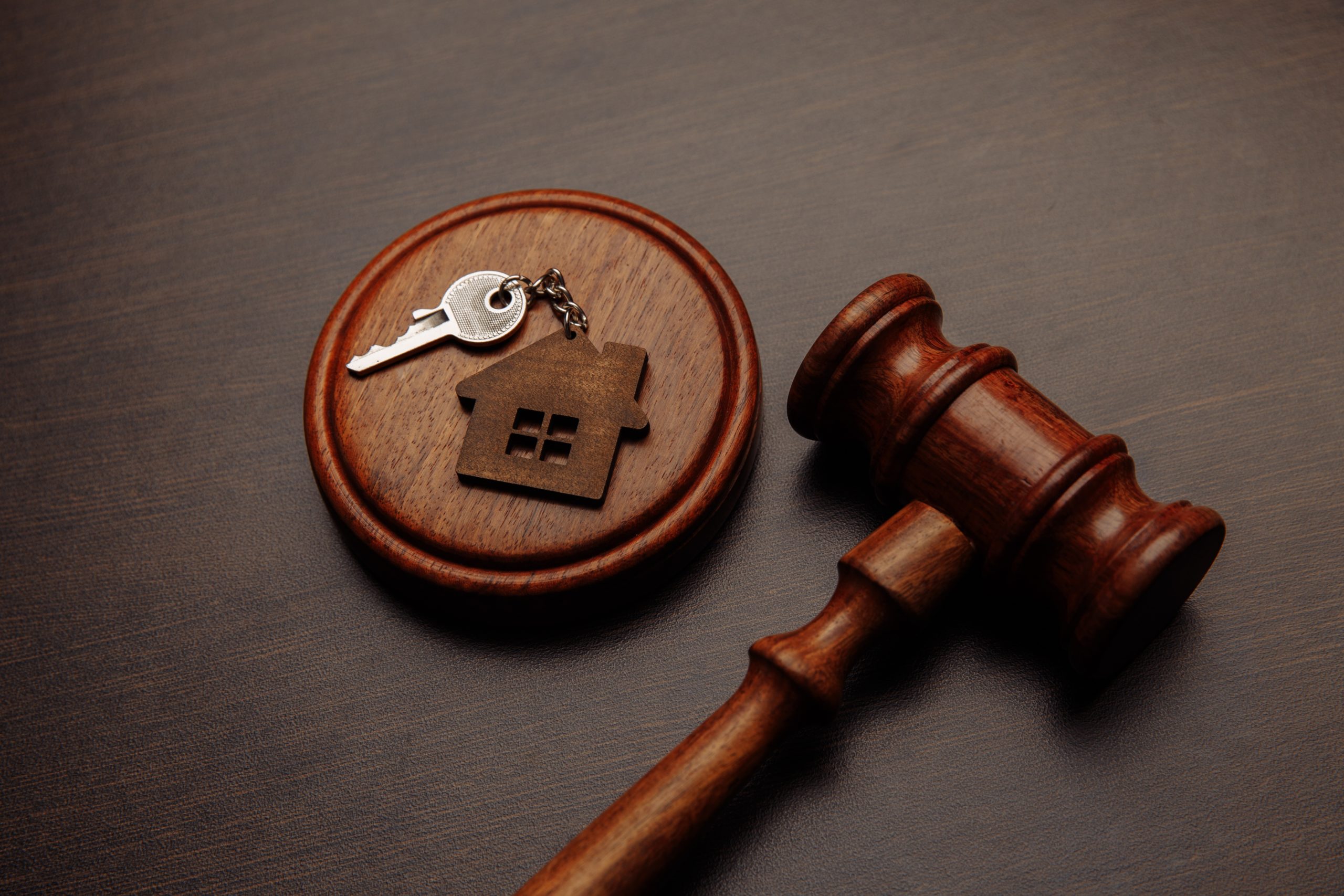Judge gavel sits next to a keychain shaped like a house